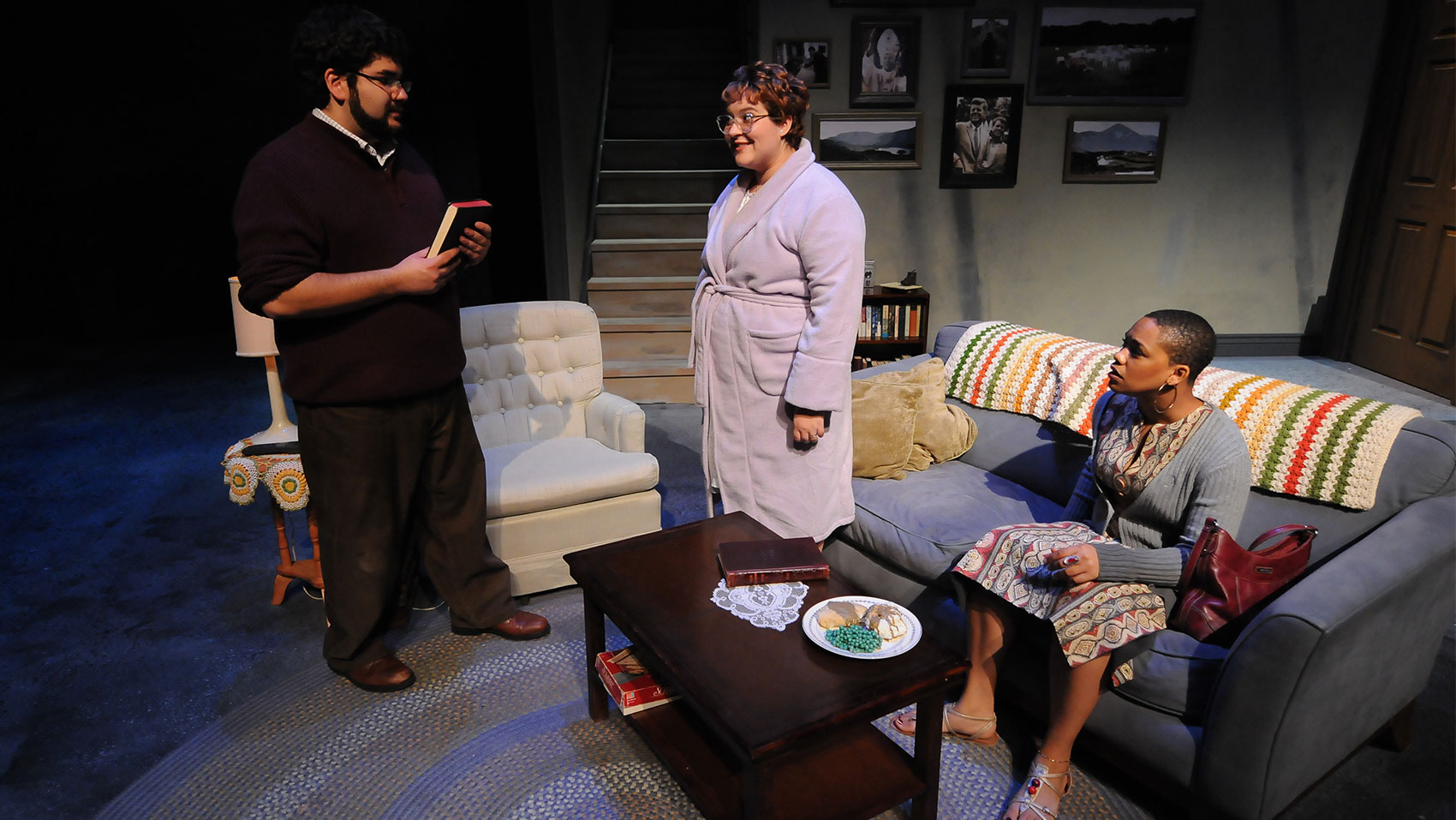 A man and two women talking in a living room