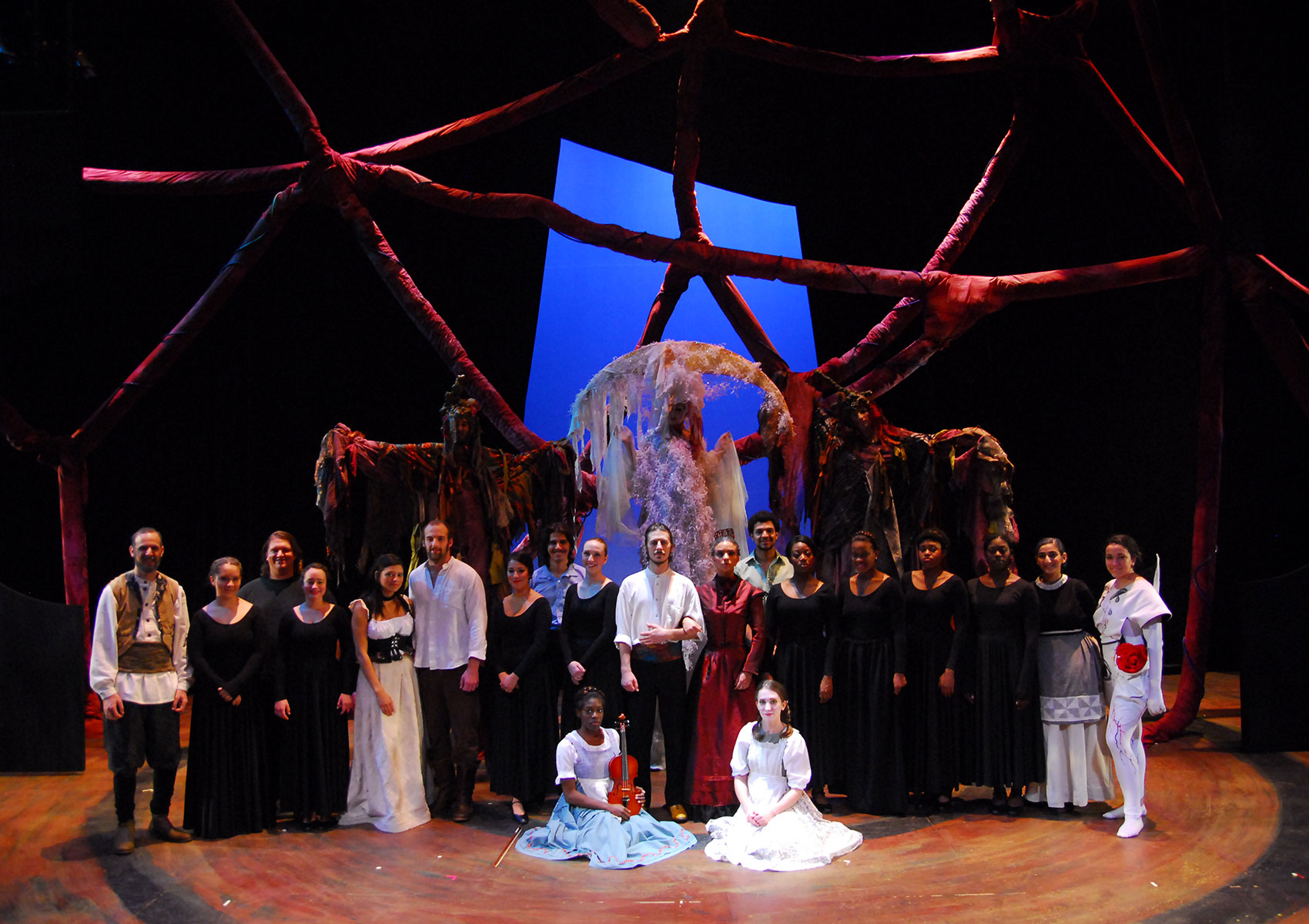 A photo of all the cast onstage in their costumes.