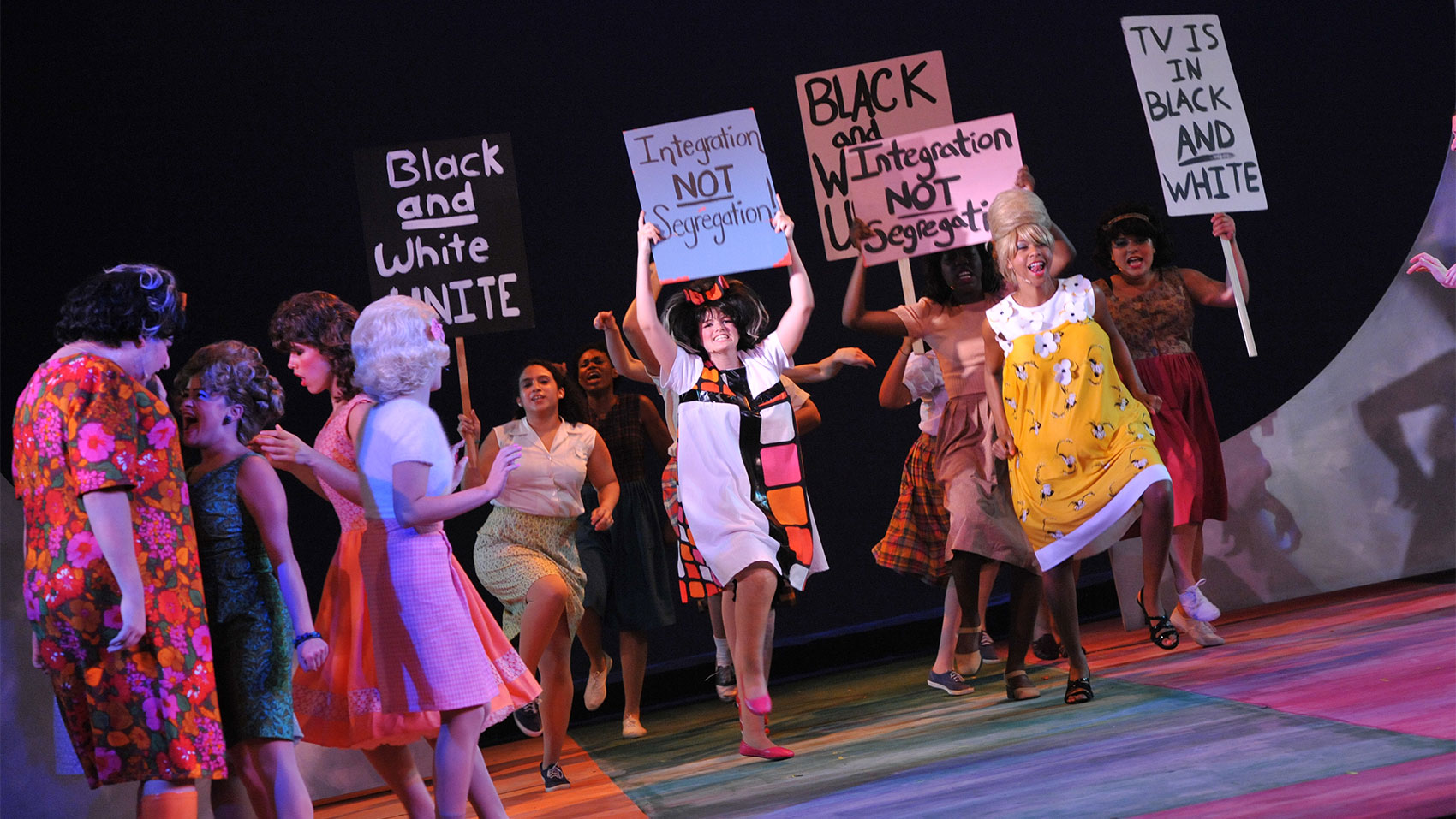 A group of people holding signs about desegregation