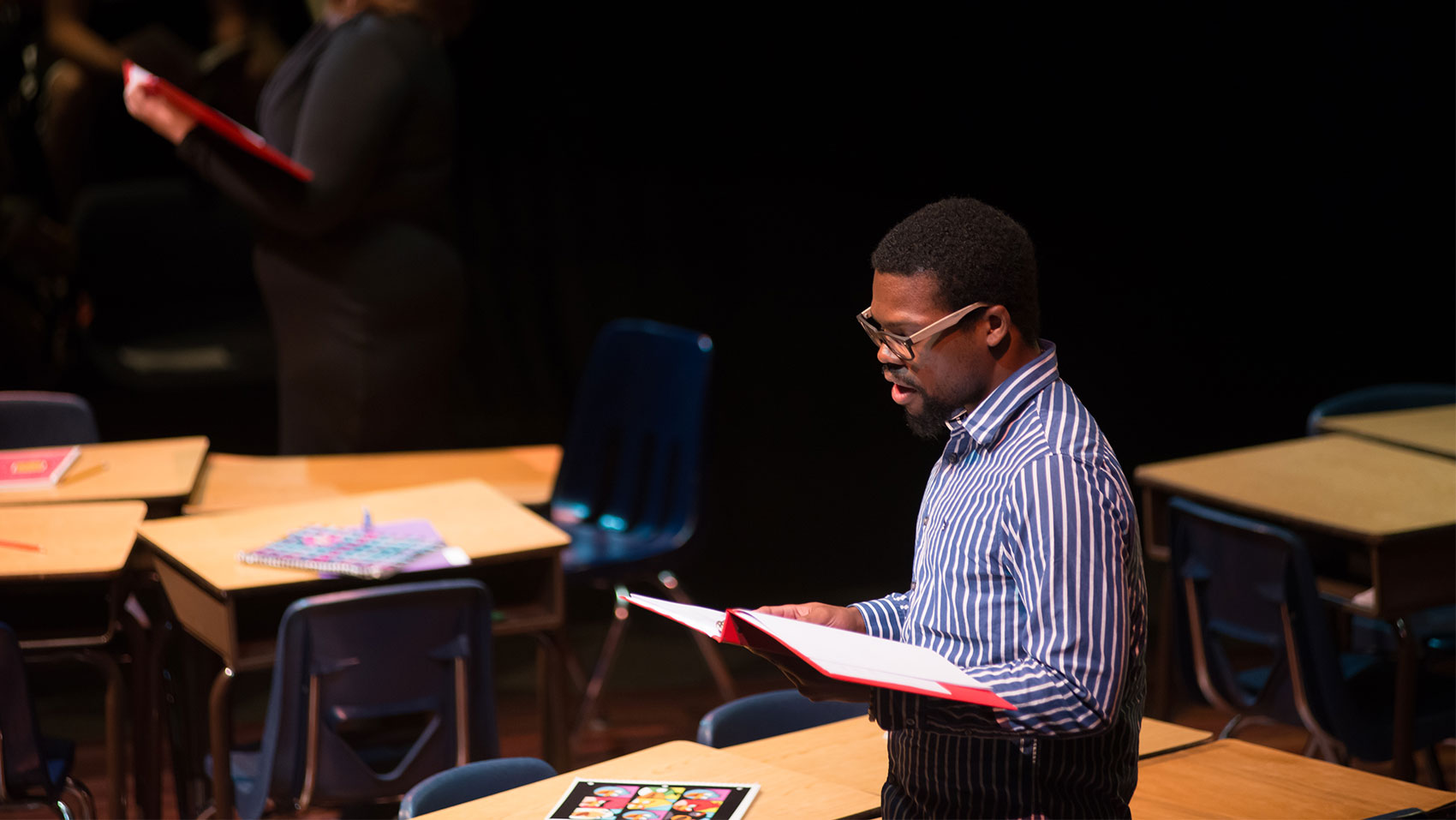 A male character is reading aloud from a book.