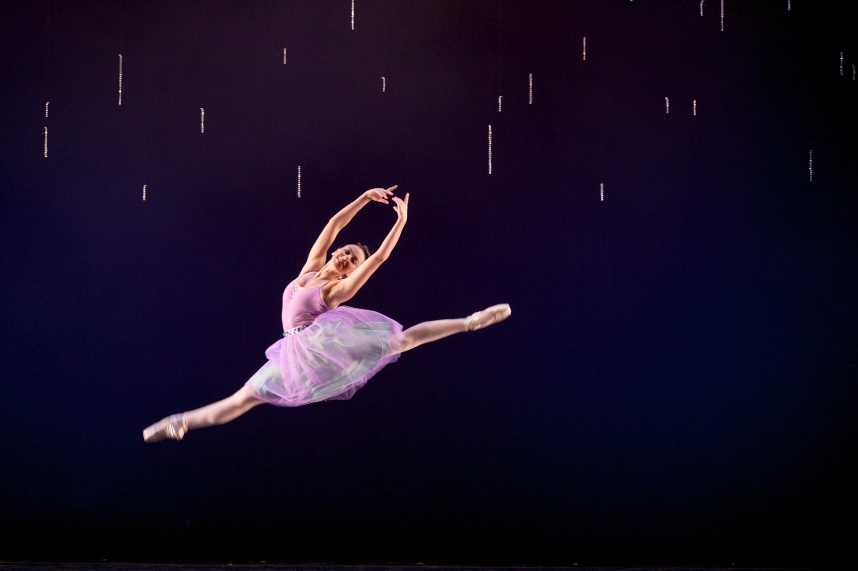 A dancer performs a split leap.