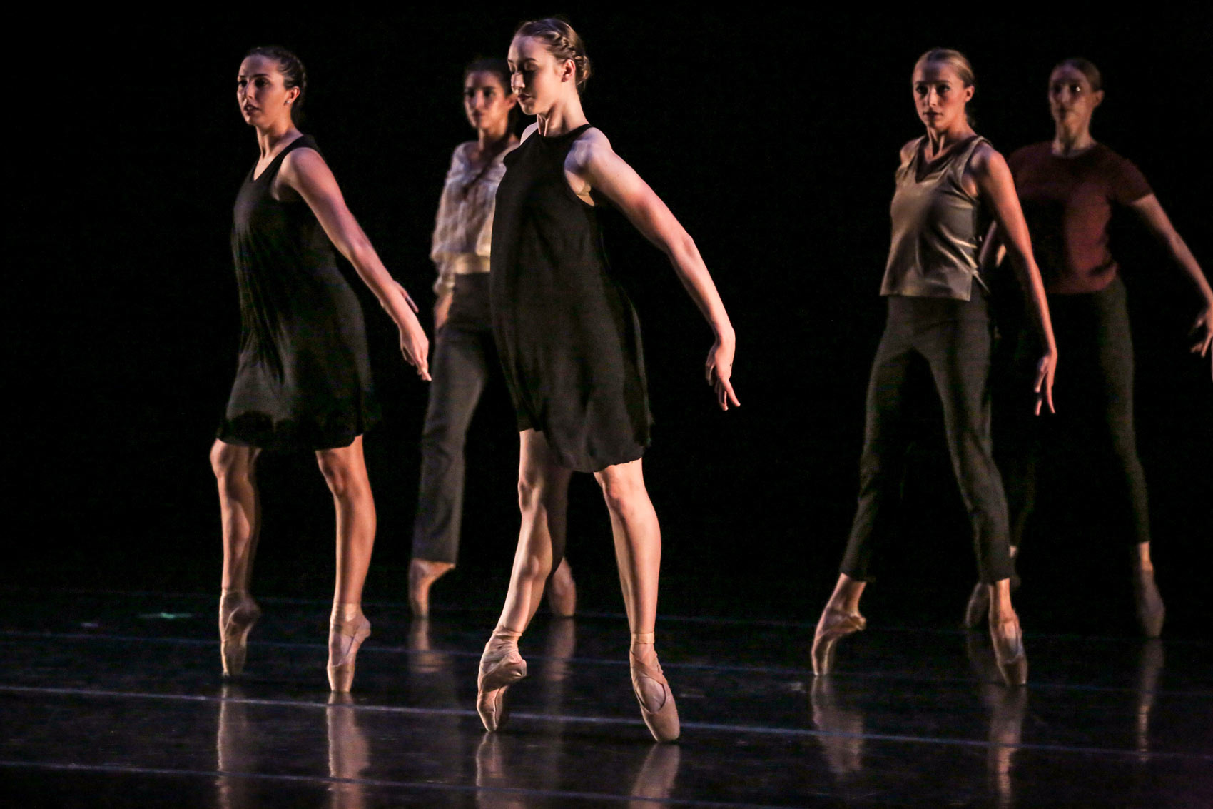 Dancers stand together on pointe.