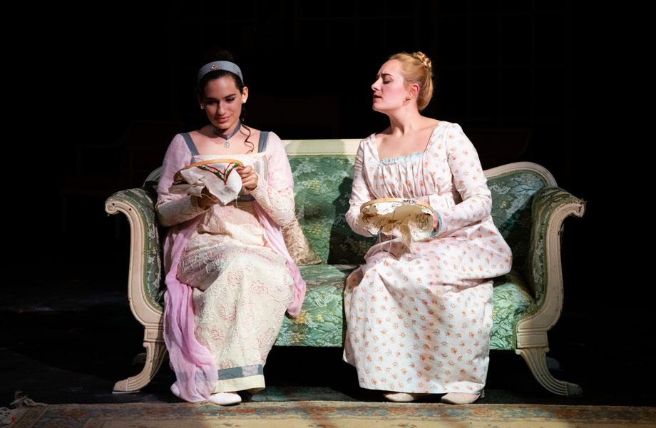 Two women characters from "Emma" sitting on a bench together.