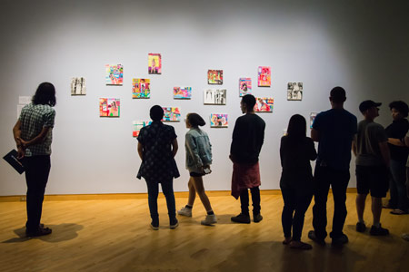 Visitors view art on the wall in the Contemporary Art Museum in the annual MFA show at USF ArtHouse.