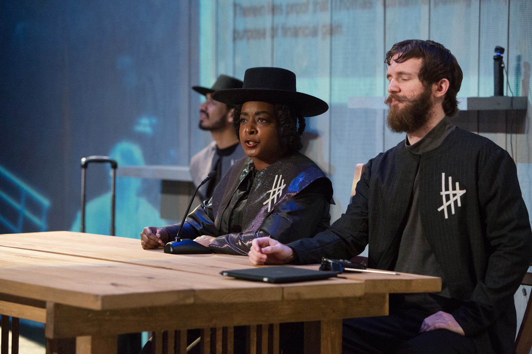 Judges convene at the witch trial, seated together at a table.