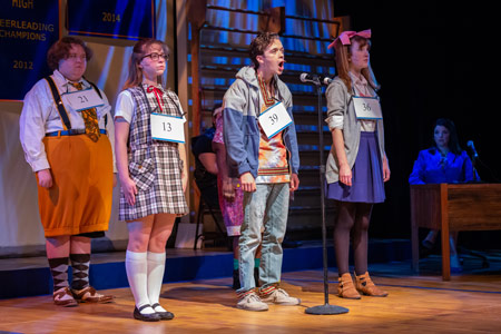 Students spelling on stage in the USF Theatre performance of "The 25th Annual Putnam County Spelling Bee."