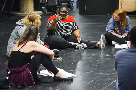 Theatre students sitting and talking together in the studio.
