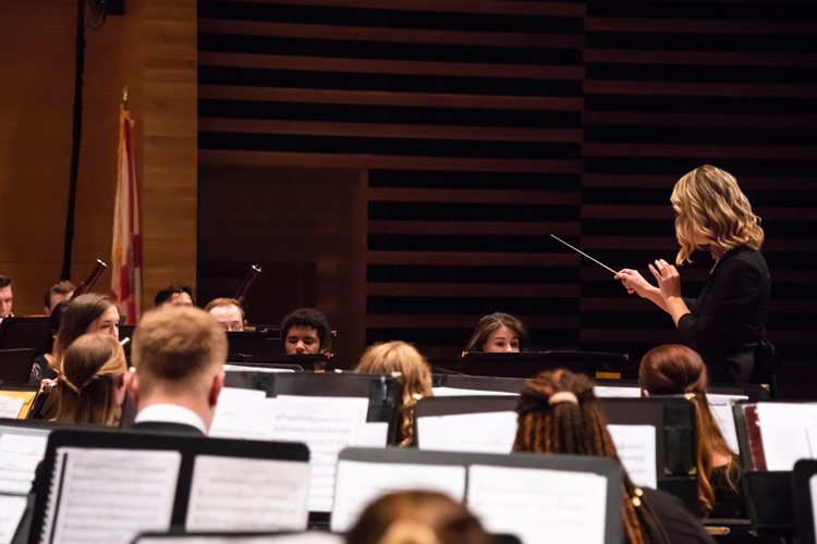 Graduate Assistant directing a musical performance.