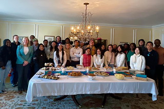 students standing behind dinner table