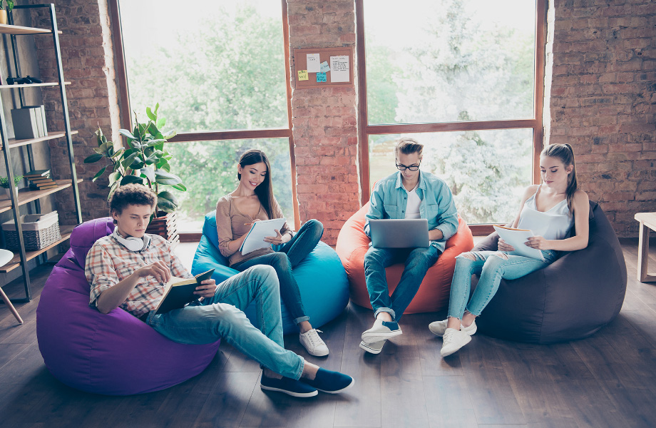 students in bean bag chairs inside dorm