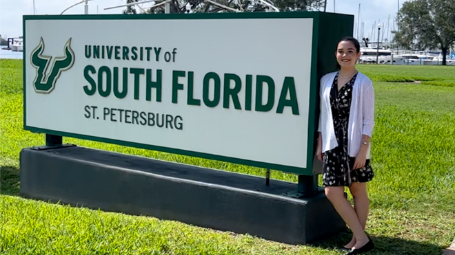 Allison Wightman posing with USF St. Petersburg sign