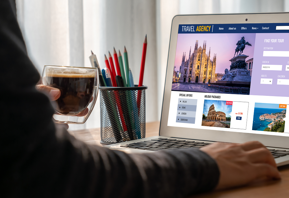 person using a laptop and holding a coffee