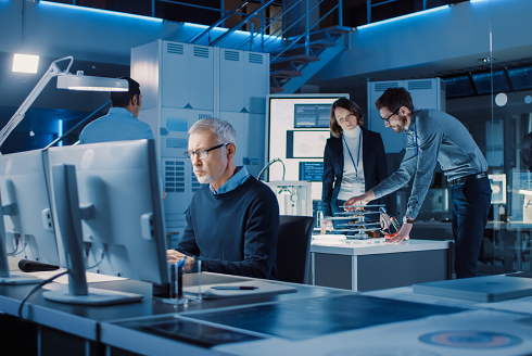 group of people working in a lab with computers