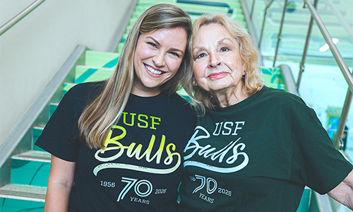 Two alums, granddaughter and grandmother, pose with USF70 shirts