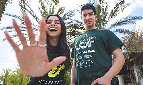 Two students wearing exclusive USF70 shirts