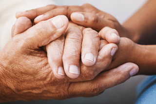 Two persons' hands clasped together