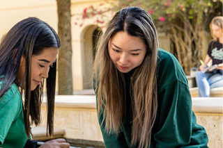 Two women looking down at a tablet
