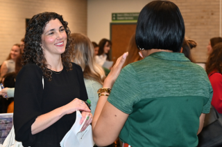 Female student smiling and talking with another woman