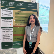 woman standing in front of research poster smiling at camera