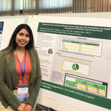 woman standing in front of her research poster.