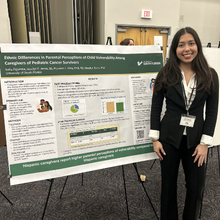 young woman in front of her researc poster.