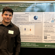 Young man in front of research poster