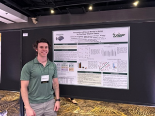Dimitri standing in front of a presentation poster