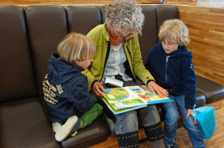 Grandmother reading a story to her grandsons 