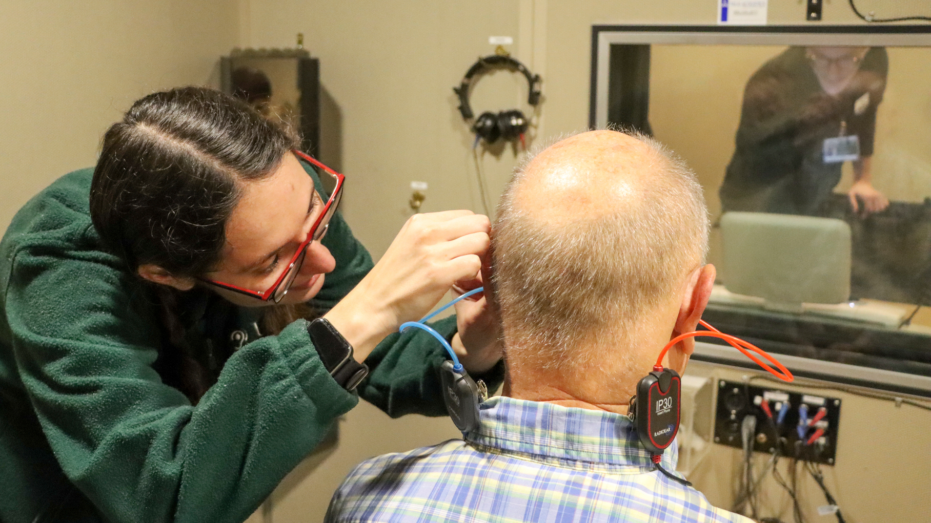 A patient being assisted in connecting various sensors and devices for a test
