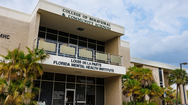 Front doors of the College of Behavioral and Community Sciences, viewed from outside.