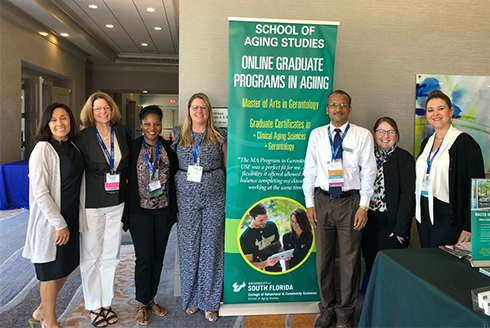 A group of aging studies students, faculty, and staff gathered at the USF School of Aging Studies informational booth at the Southern Gerontological Society's Annual Meeting and Conference.