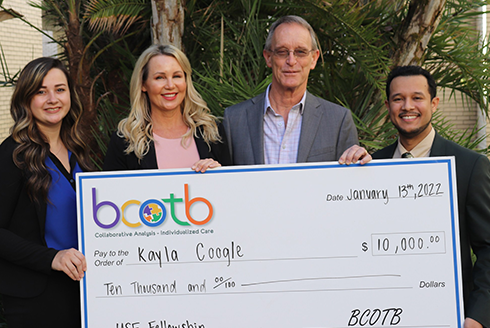 Kayla Coogle and others pose with a large check