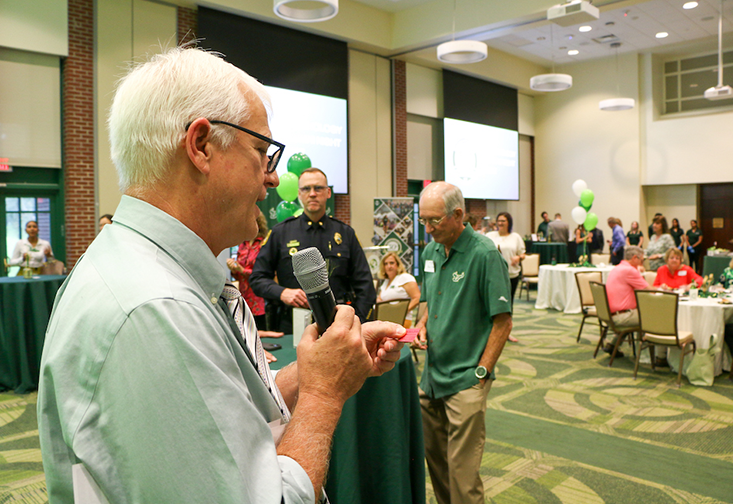 John Cochran, PhD reads a raffle ticket