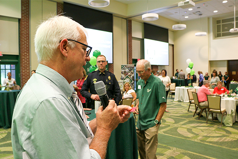 John Cochran, PhD reads a raffle ticket