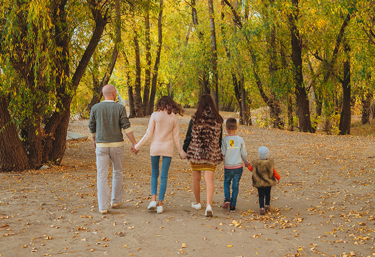 family walking on a trail away from camera