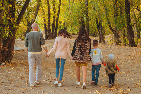 family walking on a trail away from camera