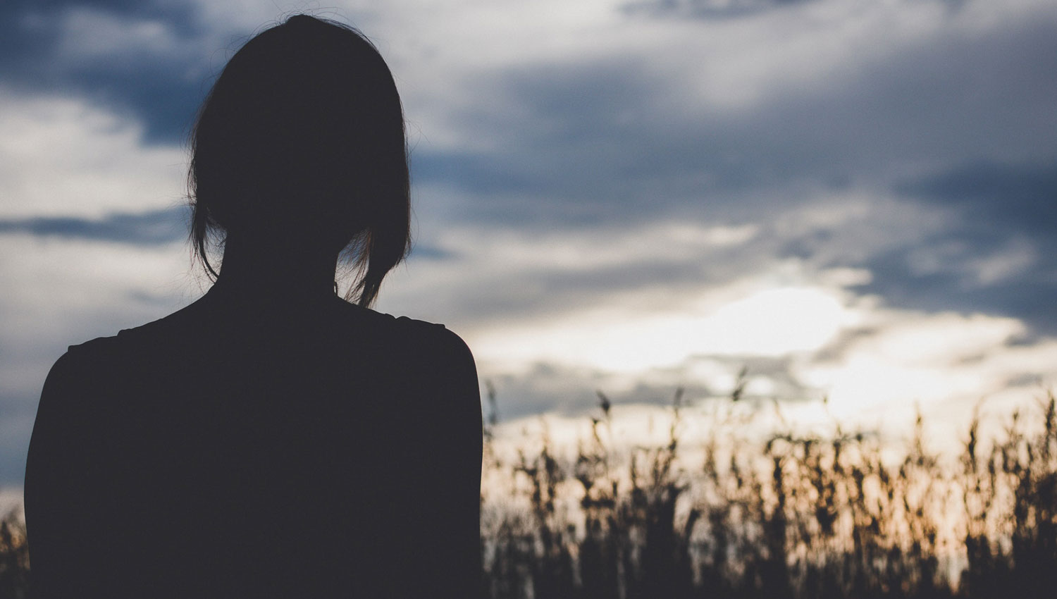 Silhouette of woman watching the sunset