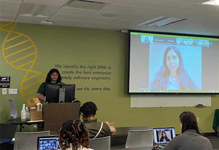 School of Social Work students pictured in classroom, surrounding large screen showing a speaker