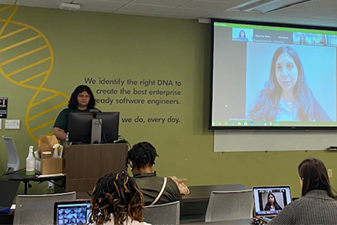 School of Social Work students pictured in classroom, surrounding large screen showing a speaker