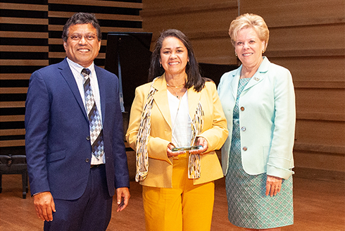 Maricel Hernandez accepts the award with President Rhea Law and Provost Prasant Mohapatra