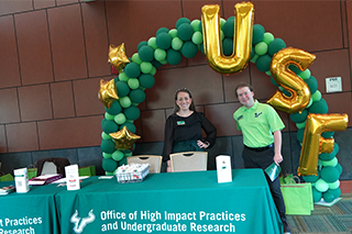 two people standing behind a table 