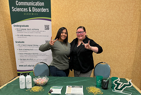 Diane Rifaie, MA, and Samantha Thomas, MA, stand at their booth at the conference in Orlando
