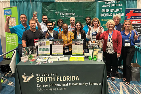 Representatives of the School of Aging Studies stand at the school's booth 