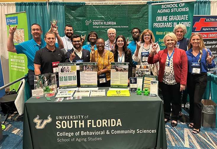 Representatives of the School of Aging Studies stand at the school's booth 