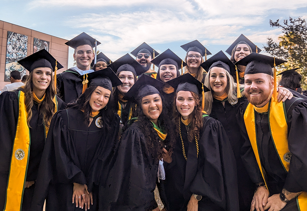 A large group of students in caps and gowns pose for the camera