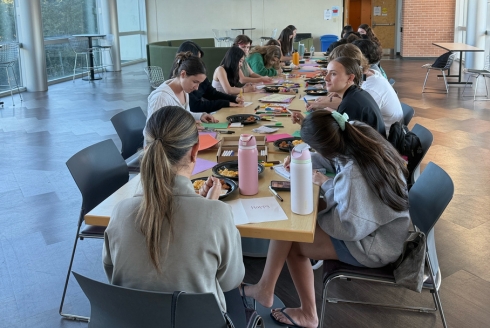 Students sitting at a table making holiday cards
