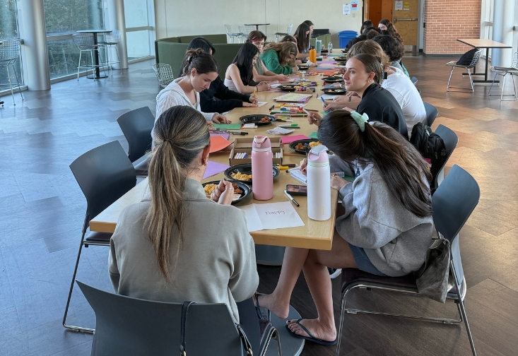 Students sitting at a table making holiday cards
