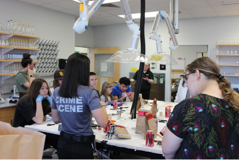Staff providing guidance to students during a crime scene scenario exercise