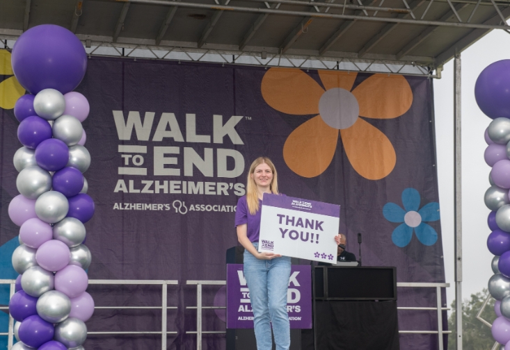 Nik Lampe on stage being recognized as an an Alzheimer’s Association funded researcher. 