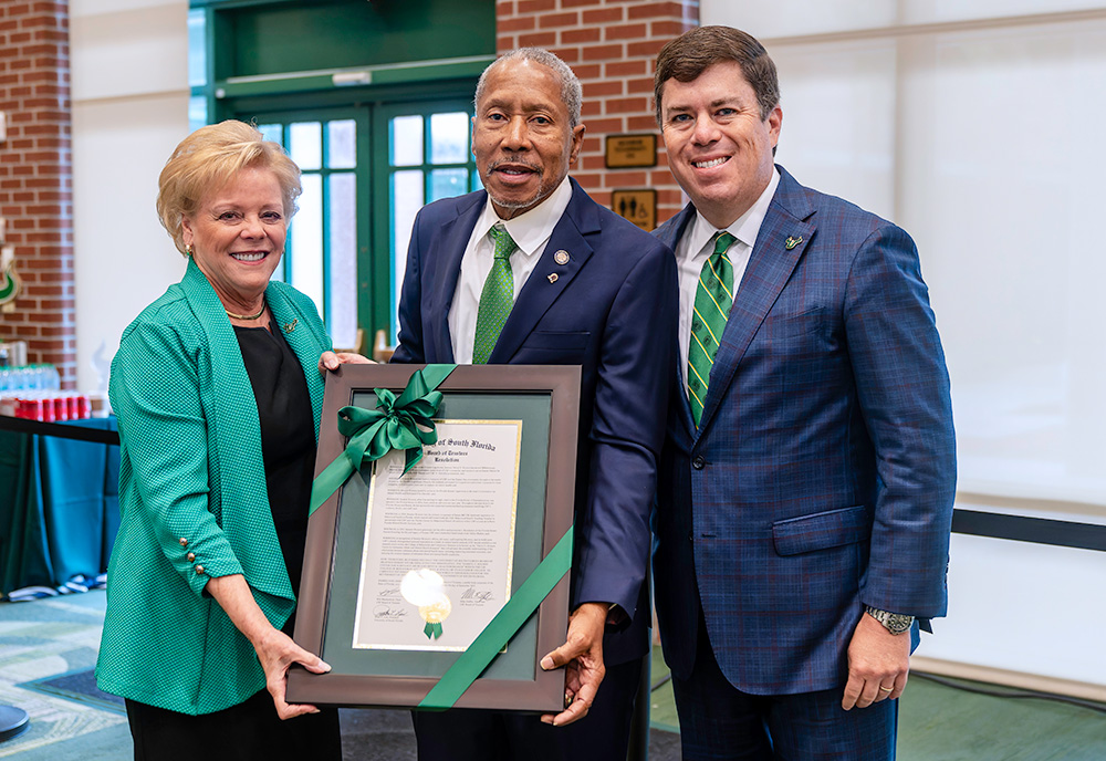 USF President Rhea Law, Sen. Darryl Rouson, and Board of Trustees Vice Chair Michael Griffin hold a copy of the resolution establishing the Darryl E. Rouson Center for Substance Abuse and Mental Health Research.